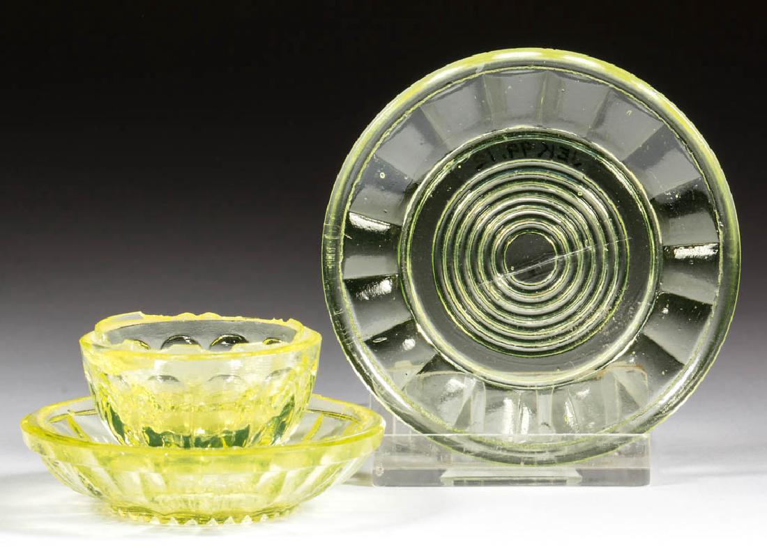 PRESSED PANELED TOY ARTICLES, LOT OF THREE: PRESSED PANELED TOY ARTICLES, LOT OF THREE, canary yellow, comprising a plate with concentric circle center, and a handless cup and saucer. Boston & Sandwich Glass Co. 1850-1870. 1 1/4" to 2 1/4" D.Un