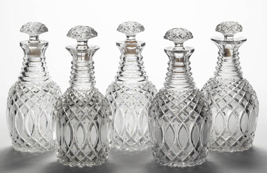 CUT ELLIPTICAL AND STRAWBERRY DIAMOND SET OF FIVE PINT: CUT ELLIPTICAL AND STRAWBERRY DIAMOND SET OF FIVE PINT DECANTERS, colorless lead glass, each Prussian form with five neck rings, thick polished mouth, and ray-cut base, original stoppers with matching