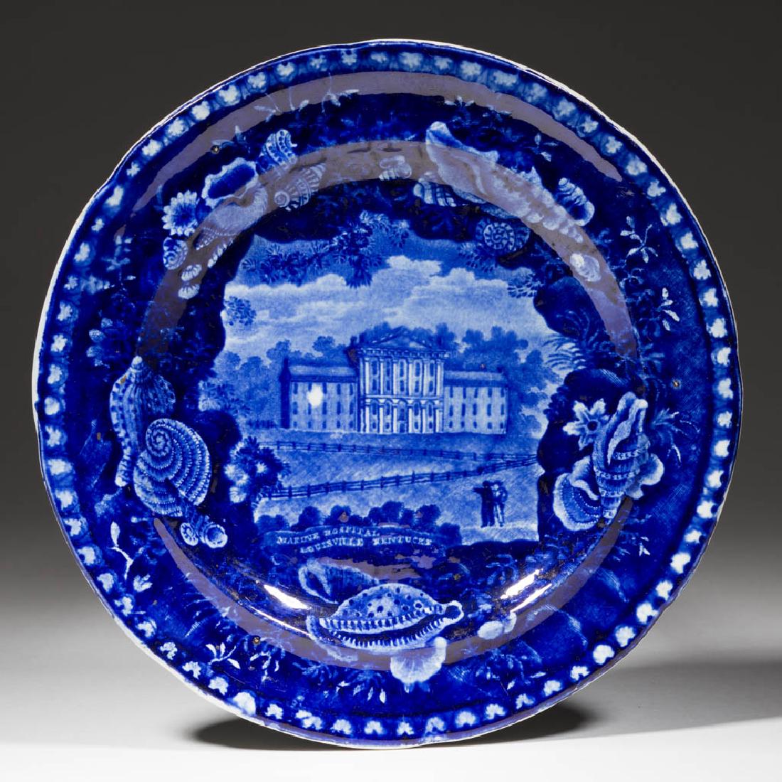 STAFFORDSHIRE TRANSFER-PRINTED AMERICAN VIEW CERAMIC: STAFFORDSHIRE TRANSFER-PRINTED AMERICAN VIEW CERAMIC PLATE, having dark blue design of the "MARINE HOSPITAL / LOUISVILLE KENTUCKY" as printed on the front below the image of a building. Impressed on b