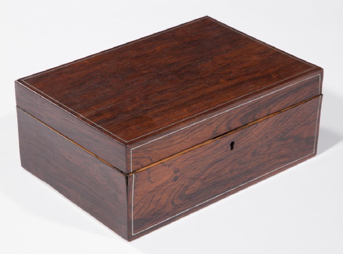INLAID ROSEWOOD SEWING BOX: INLAID ROSEWOOD SEWING BOX, hinged lid with interior sleeve, concealing an interior with original fitted tray, pewter stringing. Second half 19th century. 4" H, 9 3/4" x 6 5/8". Very good condition, s