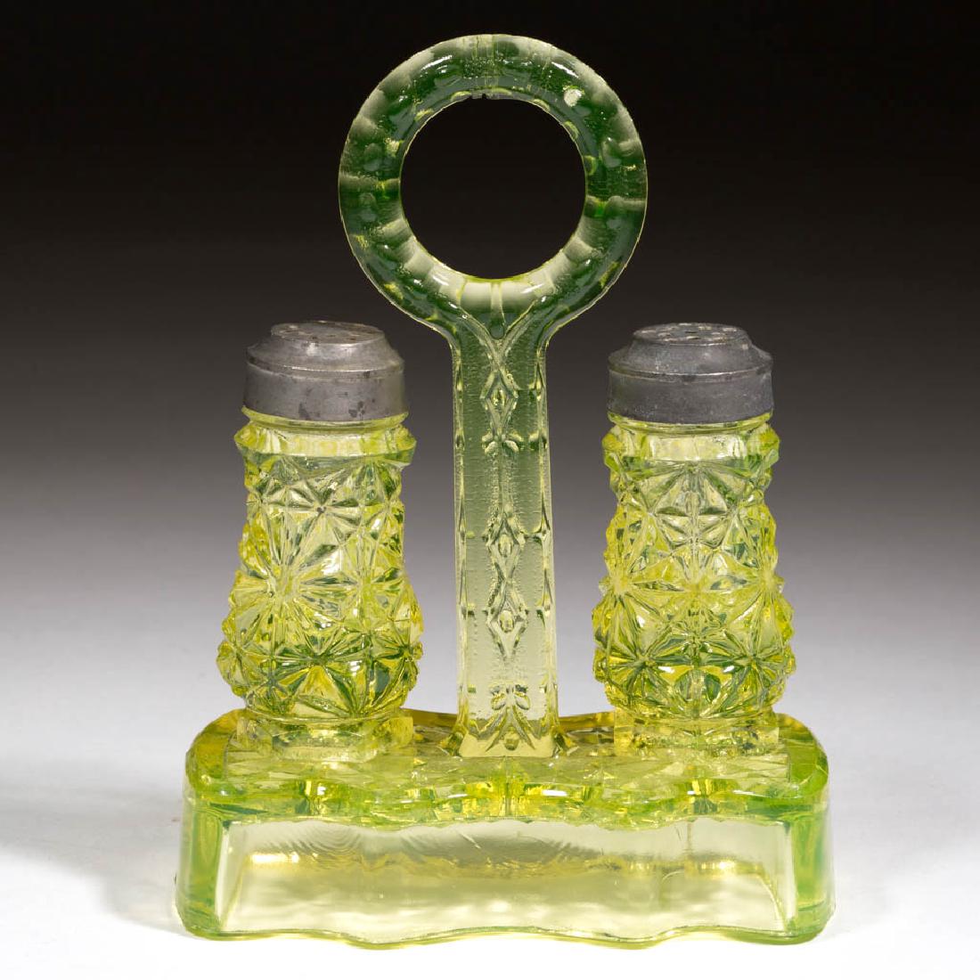 DAISY AND BUTTON PAIR OF SALT AND PEPPER SHAKERS: DAISY AND BUTTON PAIR OF SALT AND PEPPER SHAKERS, Vaseline (black lighted), with matching stand, each with a period lid. Maker unverified. 1875-1885. Maker unverified. 6" HOA, 3" H shakers. Stand unda