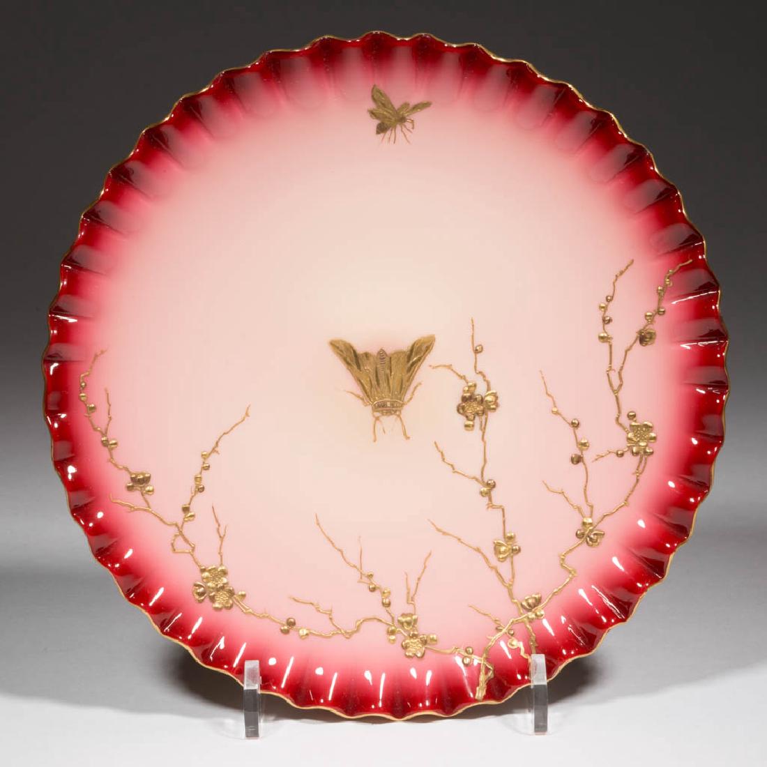 WEBB ATTRIBUTED PEACHBLOW-STYLE PLAQUE / PLATE: WEBB ATTRIBUTED PEACHBLOW-STYLE PLAQUE / PLATE, glossy with gilt enamel-decoration, ruffled rim, polished pontil mark. Thomas Webb & Sons. Fourth quarter 19th century. 9" D.Undamaged.Literature: Paral