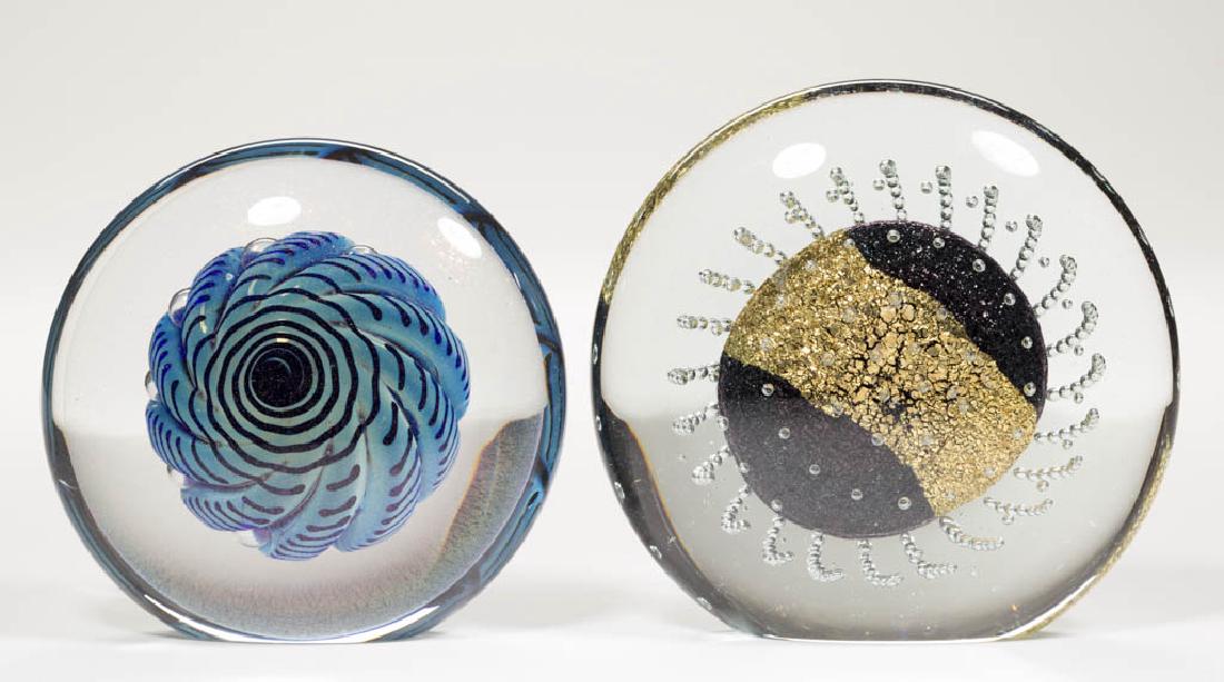 EICKHOLT UPRIGHT STUDIO ART GLASS PAPERWEIGHTS, LOT OF: EICKHOLT UPRIGHT STUDIO ART GLASS PAPERWEIGHTS, LOT OF TWO, colorless, comprising a blue swirled seashell with iridescence at the surface, and an iridescent foil oval with extending air-trap tendrils,