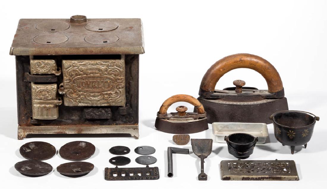 CAST-IRON AND TIN TOY COOK RANGE STOVE AND RELATED: CAST-IRON AND TIN TOY COOK RANGE STOVE AND RELATED ARTICLES, LOT OF 19, comprising a "NOVELTY" toy stove with original nickel finish, working baffle, opening furnace and oven doors, and four original 