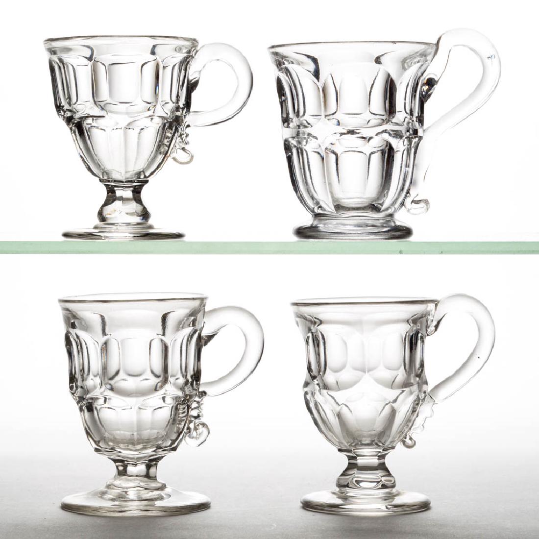 ASHBURTON HANDLED EGG CUPS, LOT OF FOUR: ASHBURTON HANDLED EGG CUPS, LOT OF FOUR, colorless lead glass, including a squared Ashburton example, each with an applied handle, two with polished pontil marks. Boston & Sandwich Glass Co., New Engl