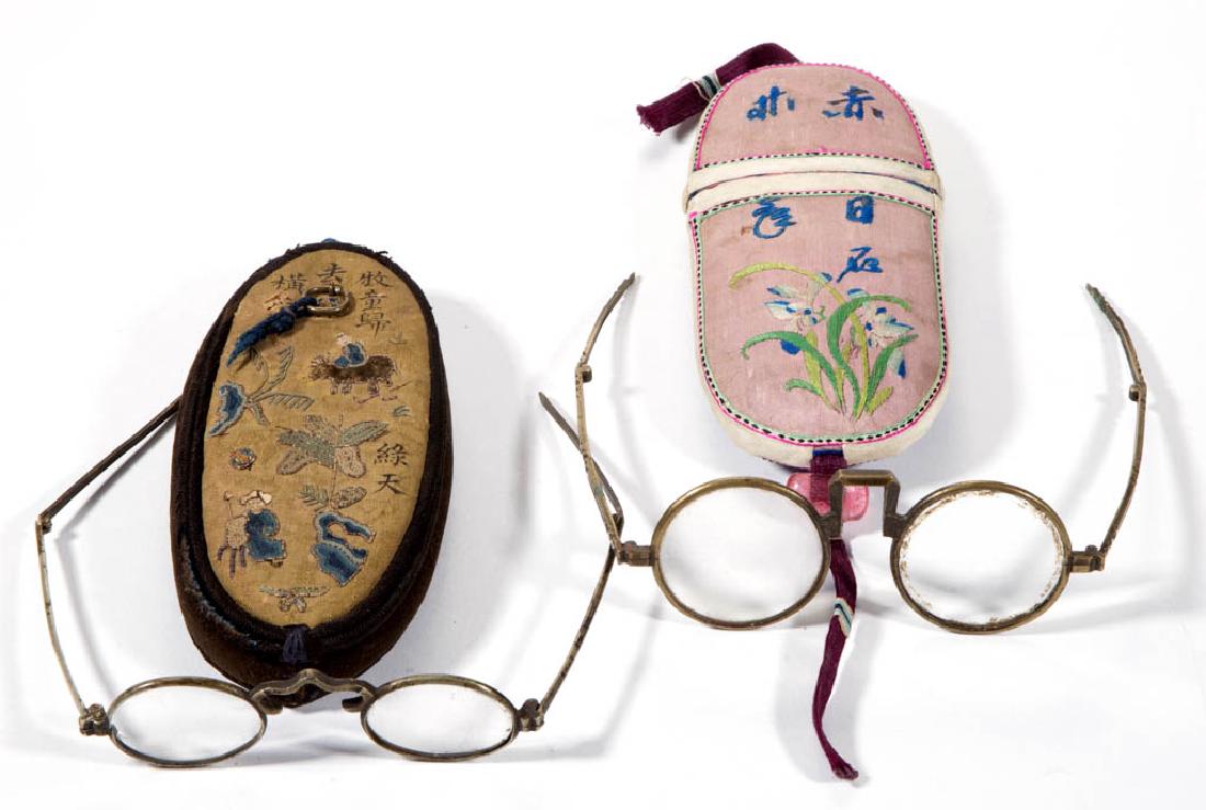 CHINESE EMBROIDERED SILK CASE EYEGLASSES AND CASES, LOT: CHINESE EMBROIDERED SILK CASE EYEGLASSES AND CASES, LOT OF TWO, one having embroidered flowers and a poem on one side, characters over blue ground on the opposite, copper rimmed glasses with folding t