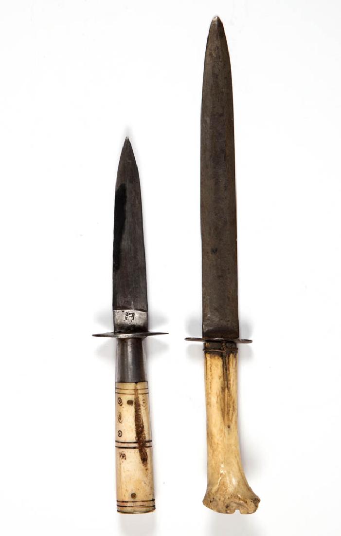 BONE-HANDLED DAGGERS, LOT OF TWO: BONE-HANDLED DAGGERS, LOT OF TWO each double-edged, comprising a likely Middle Eastern or North African example, impressed marks to ricasso, through tang, carved bands and circlets to handle, and bras