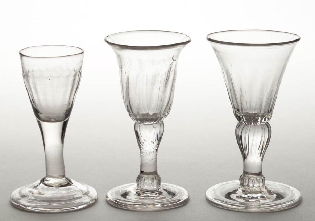 ASSORTED PATTERN-MOLDED WINE GLASSES, LOT OF THREE: ASSORTED PATTERN-MOLDED WINE GLASSES, LOT OF THREE, colorless, two lead glass comprising one with 20 basal flutes, and one with 12 ribs on lower bowl and across the inverted baluster stem, and a non-l