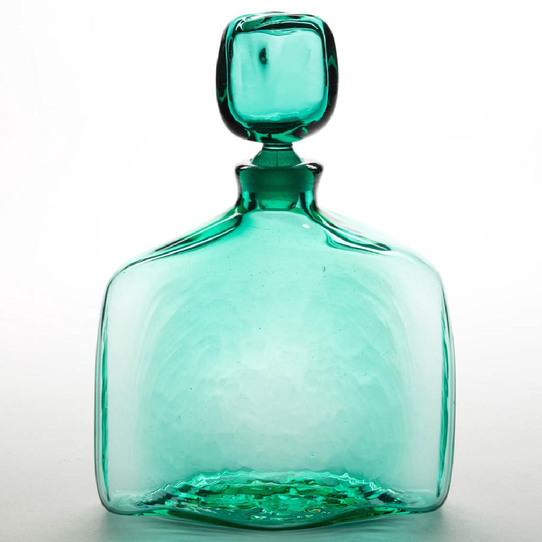 BLENKO NO. 566 GLASS - WAYNE HUSTED DECANTER: BLENKO NO. 566 GLASS - WAYNE HUSTED DECANTER, teal, original stopper, factory-ground interior neck and stopper extension.Circa 1957. 10 1/2" HOA, 7 1/2" H bottle, 7 1/2" WOA.Undamaged.Literature: Blen