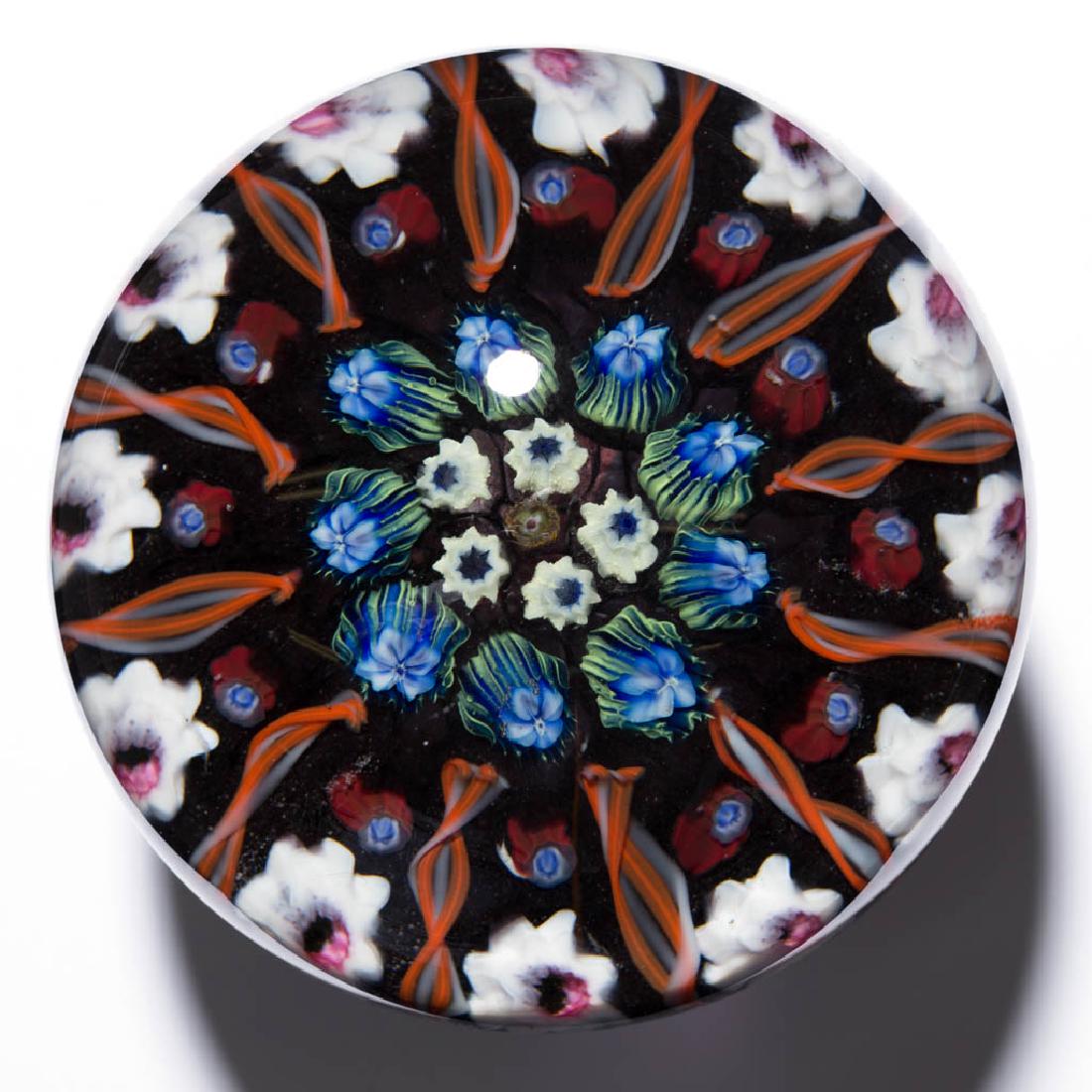 EARLY PAUL YSART STUDIO ART GLASS MILLEFIORI: EARLY PAUL YSART STUDIO ART GLASS MILLEFIORI PAPERWEIGHT, colorless with a grey tint, small amber floral central cane surrounded by white floral canes, second row with shaded green and blue floral can