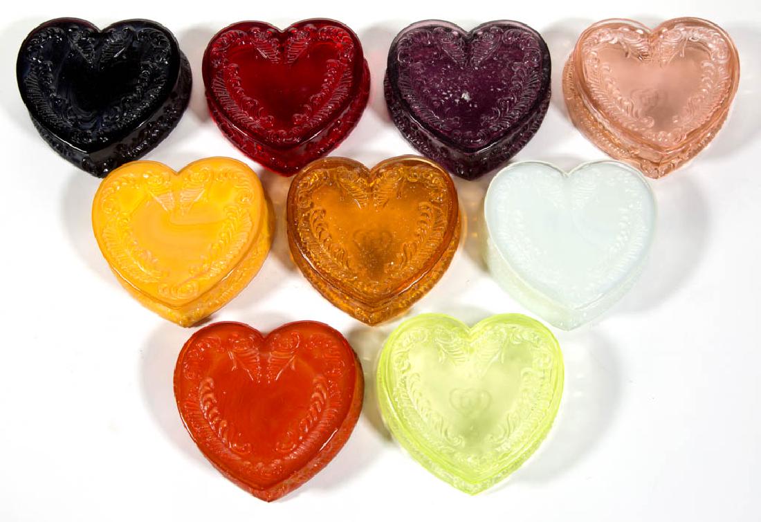 DEGENHART GLASS HEART JEWEL BOXES, LOT OF NINE: DEGENHART GLASS HEART JEWEL BOXES, LOT OF NINE, various colors, including a Bloody Mary / Tomato, a Buttercup Slag, a Honey, a Ruby, and a Vaseline (black lighted) example. Each with Degenhart "D" in 