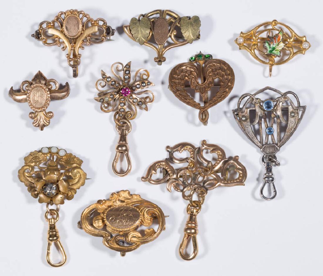 ANTIQUE / VINTAGE POCKET WATCH LAPEL BROOCH HOOKS, LOT: ANTIQUE / VINTAGE POCKET WATCH LAPEL BROOCH HOOKS, LOT OF TEN, comprising a silver-tone example and nine gold-filled examples, one set with seed pearls. Fourth quarter 19th/first quarter 20th century.