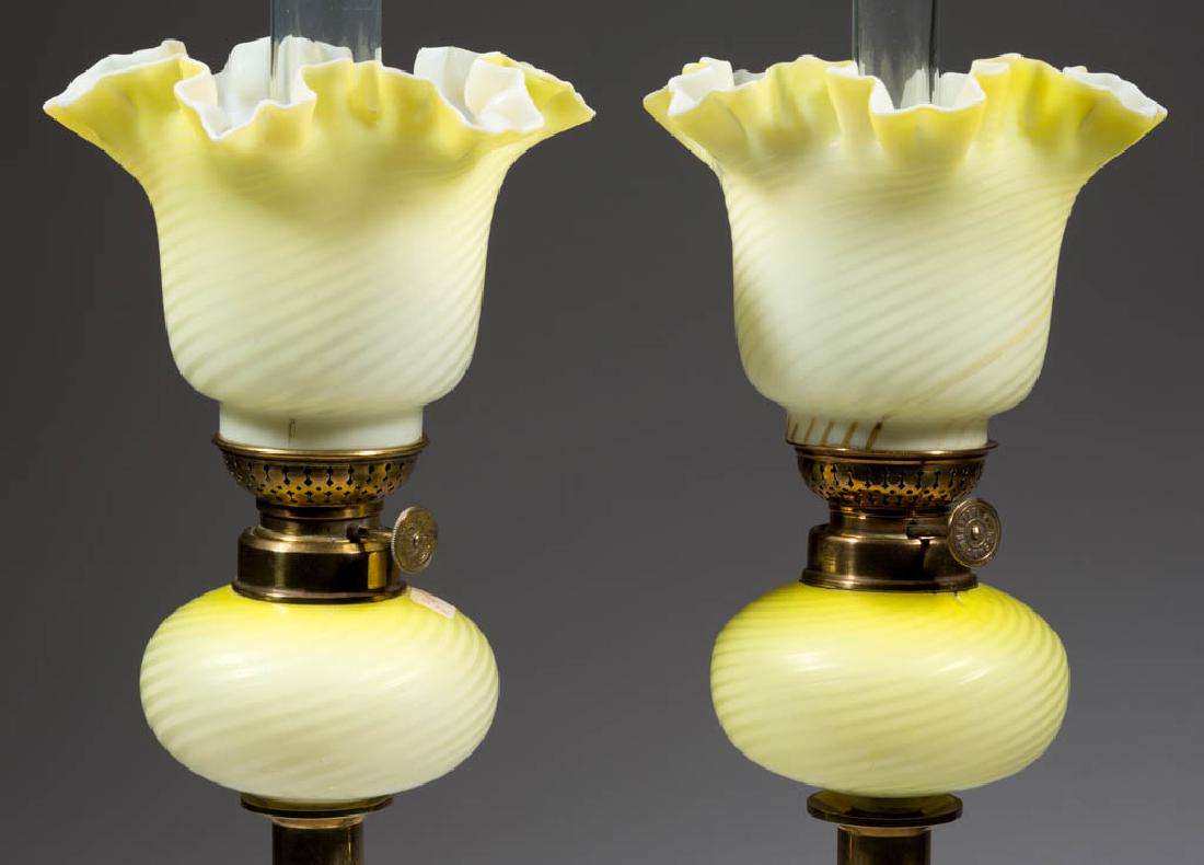 SWIRL AIR-TRAP MOTHER-OF-PEARL SATIN GLASS PEG LAMPS,: SWIRL AIR-TRAP MOTHER-OF-PEARL SATIN GLASS PEG LAMPS, PAIR, dark to light lemon yellow globular-form fonts, matching patterned cylinder-form shades with star-form crimped rims, similar period brass co