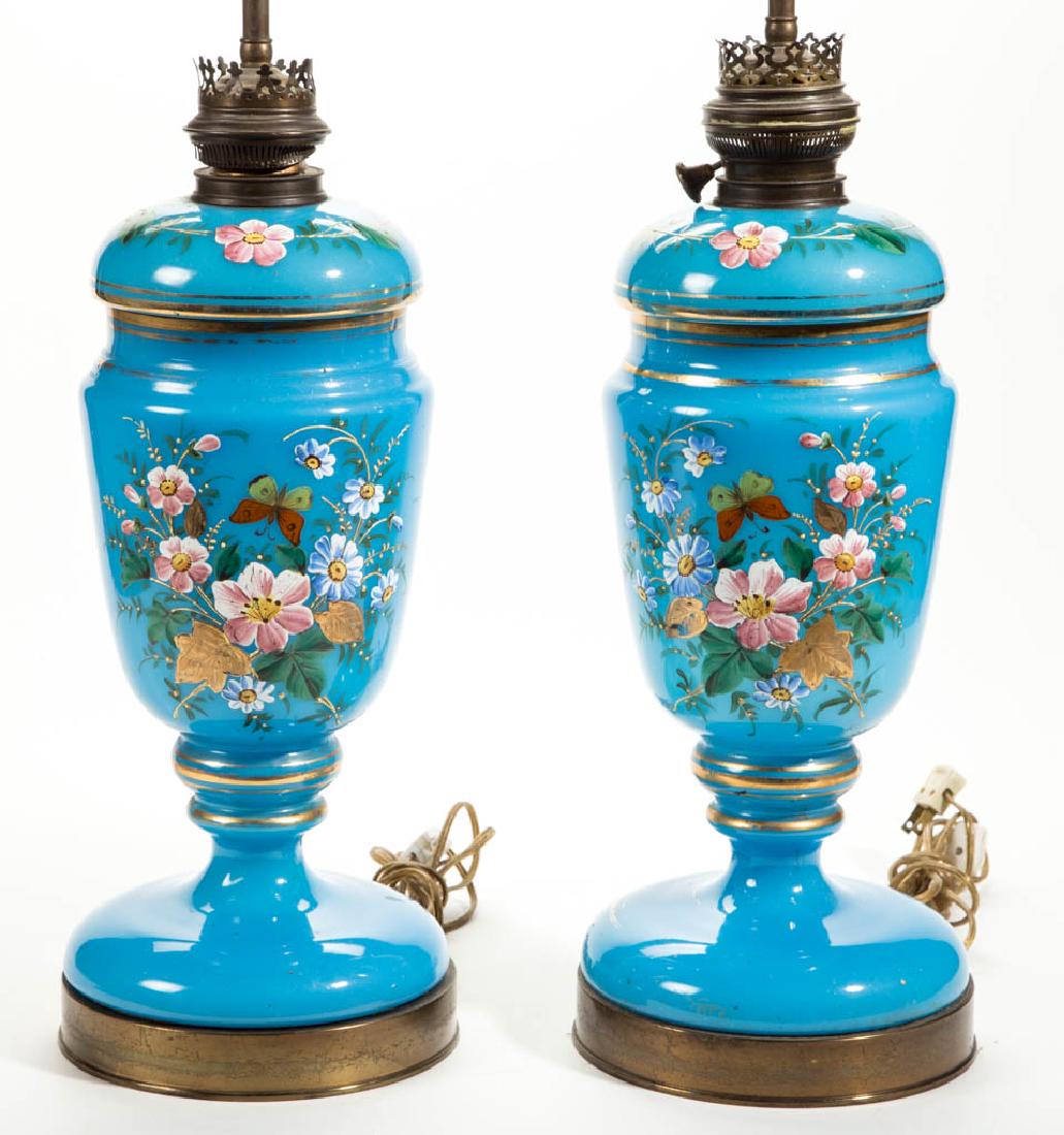 EUROPEAN OPALINE AND ENAMEL-DECORATED PAIR OF LAMPS: EUROPEAN OPALINE AND ENAMEL-DECORATED PAIR OF LAMPS, translucent blue with gilt decoration, each tall urn form with matching floral polychrome-enamel decoration, each fitted onto a brass base, each ha