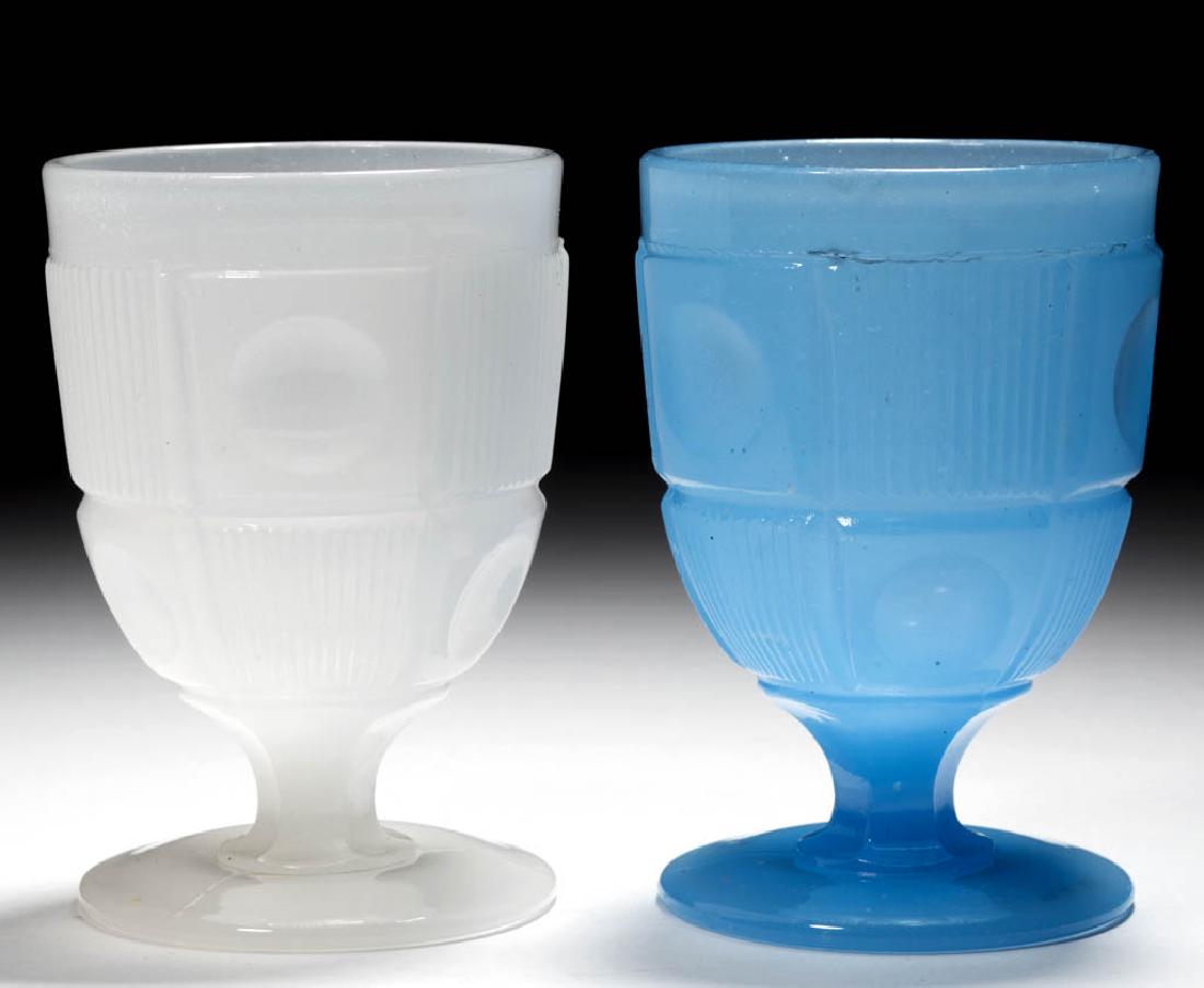 BULL'S EYE AND BAR EGG CUPS / POMADES, LOT OF TWO: BULL'S EYE AND BAR EGG CUPS / POMADES, LOT OF TWO, comprising an alabaster/clambroth and a translucent cornflower blue, each deep cup raised on a circular foot. Boston & Sandwich Glass Co. 1850-1870.