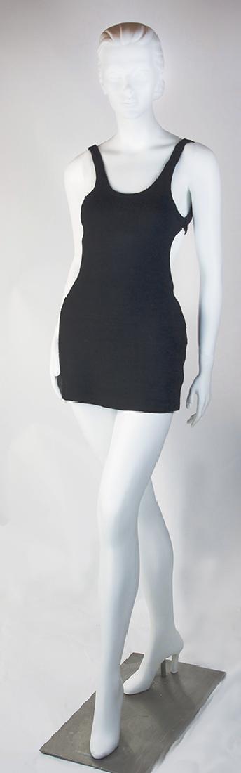 FITRIGHT SKIRTED WOOL CUT-OUT SWIMSUIT: FITRIGHT SKIRTED WOOL CUT-OUT SWIMSUIT, black, knitted woolen suit with Fitright label, having tank top with cut-out sides and deep U-back, trunk-styled shorts beneath skirt. Circa 1930. Measures to f