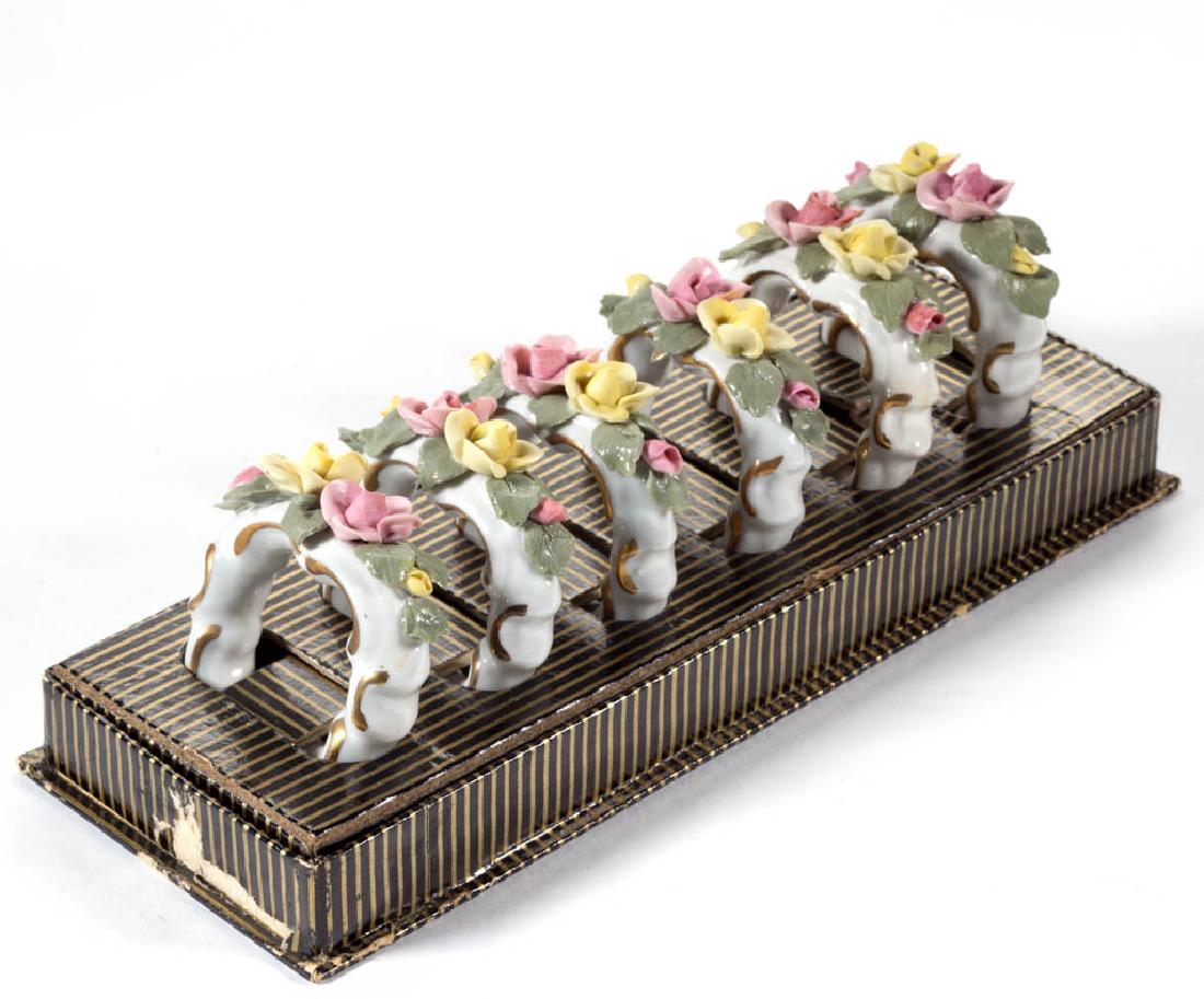 DRESDEN PORCELAIN NAPKIN RINGS, LOT OF SIX: DRESDEN PORCELAIN NAPKIN RINGS, LOT OF SIX, various colors, white ground with polychrome floral decoration, each signed. 20th century. 1 3/4" DOA.One example with a minor loss to one leaf, remainder u
