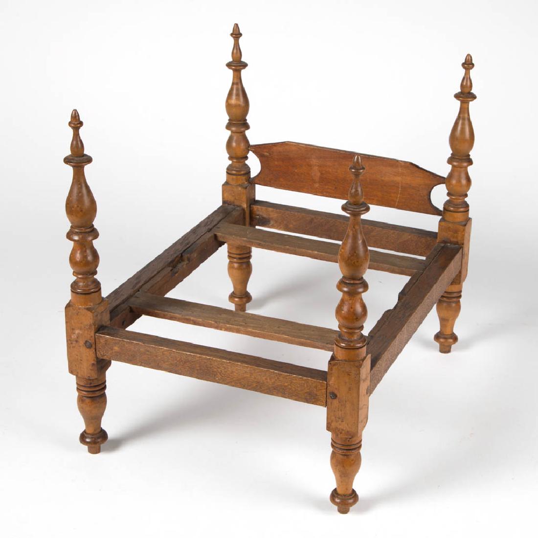 MAPLE AND OAK CHILD'S / DOLL FOUR-POSTER BED: MAPLE AND OAK CHILD'S / DOLL FOUR-POSTER BED, baluster-form turned post, simple headboard, three board slat construction. First half 19th century. 14 1/4" HOA, 11 7/8" x 15 1/2".Very good overall cond