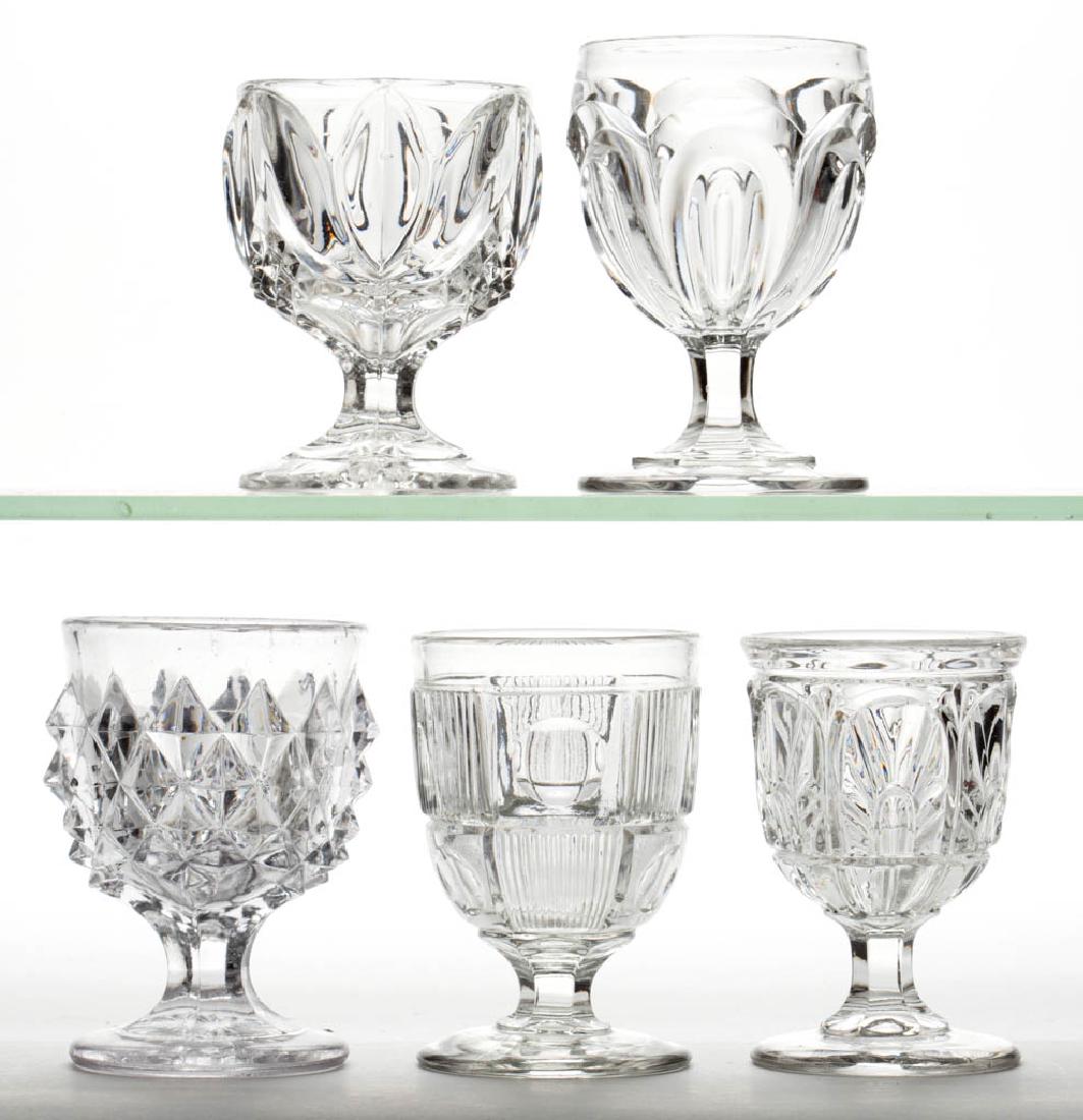 ASSORTED FLINT EAPG EGG CUPS, LOT OF FIVE: ASSORTED FLINT EAPG EGG CUPS, LOT OF FIVE, colorless leaded glass, comprising a Giant Sawtooth, Seneca Loop, Gothic, Bullseye and Bar, and a Tulip and Sawtooth. Various makers. Third quarter 19th cent