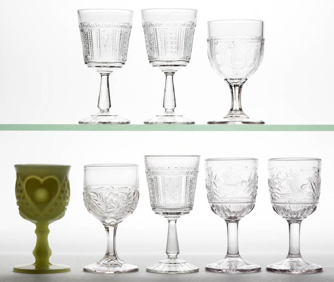 ASSORTED EAPG WINE GLASSES, LOT OF EIGHT: ASSORTED EAPG WINE GLASSES, LOT OF EIGHT, colorless and custard, including two Hummingbird, Parrot and Fan, Heart and Thumbprint, and Thistle examples. Various makers. Fourth quarter 19th/first quarte