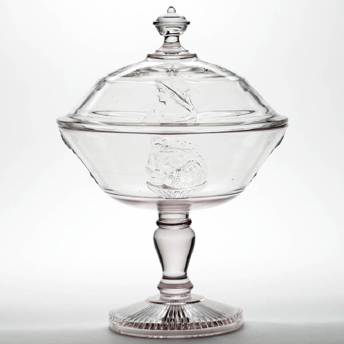 ACTRESS / OPERA (OMN) COVERED COMPOTE: ACTRESS / OPERA (OMN) COVERED COMPOTE, colorless and frosted, high standard. Adams & Co. Circa 1880. 12 3/4" HOA, 8 1/4" D. Very good condition overall with a moderate chip to the cover flange, modera