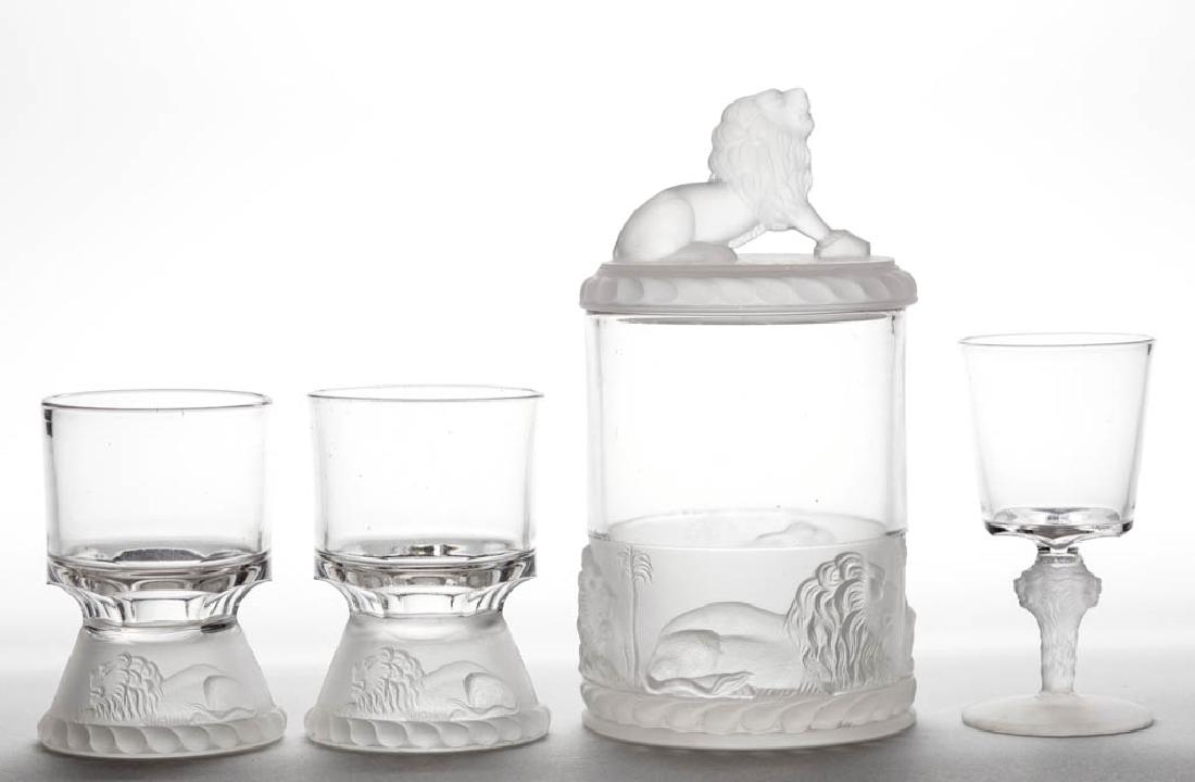 LION - FROSTED ARTICLES, LOT OF FOUR: LION - FROSTED ARTICLES, LOT OF FOUR, colorless and frosted, comprising a jam/pickle jar, two egg cups, and a wine. Gillinder & Sons. Fourth quarter 19th century. 4 3/4" to 6 3/4" HOA.Jam and one egg