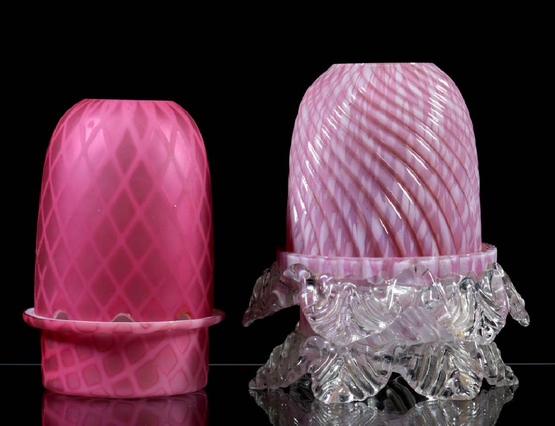 ASSORTED CASED GLASS FAIRY LAMPS, LOT OF TWO: ASSORTED CASED GLASS FAIRY LAMPS, LOT OF TWO, cased pink, two-part construction, fairy-size domes, comprising a pink rib swirl with opal spatter and factory ground contours to two sides, fitted on a m