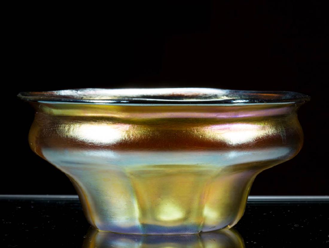 TIFFANY FAVRILE GOLDEN IRIDESCENT ART GLASS FINGER BOWL: TIFFANY FAVRILE GOLDEN IRIDESCENT ART GLASS FINGER BOWL, factory-polished base and pontil mark, signed "L.C.T.". Tiffany Studios. First quarter 20th century. 2" H, 4 1/2" D rim. Undamaged. Deaccession