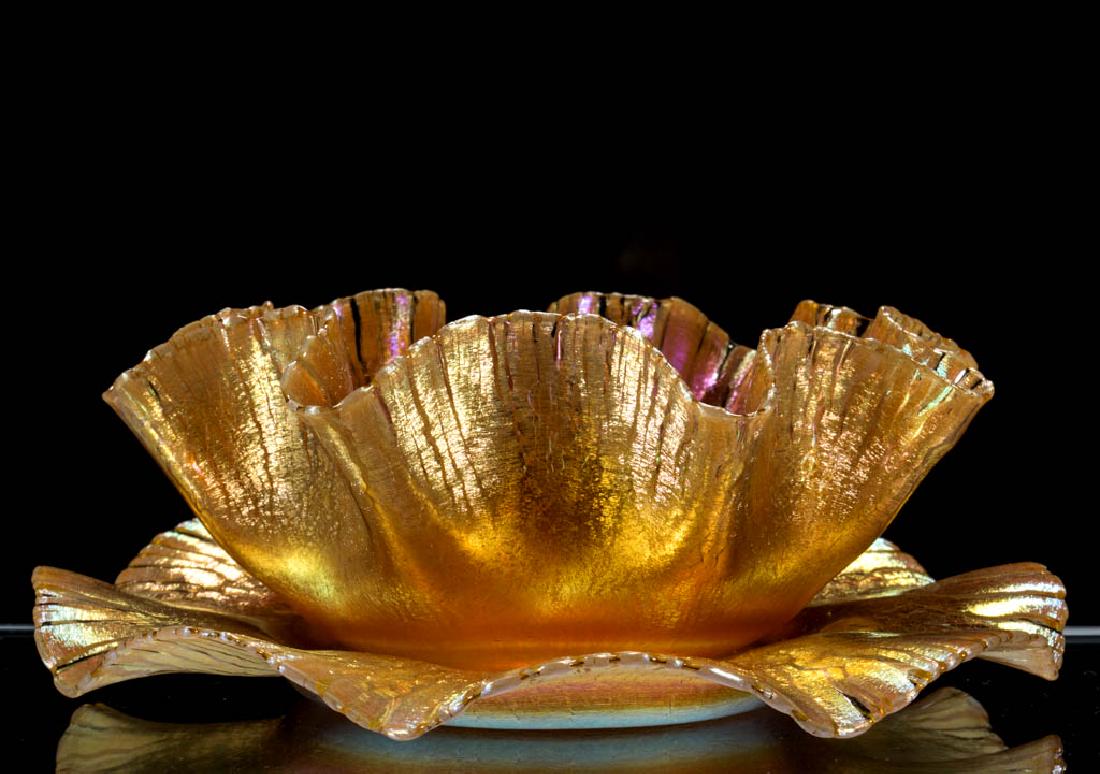 TIFFANY FAVRILE "EARL" IRIDESCENT ART GLASS FINGER BOWL: TIFFANY FAVRILE "EARL" IRIDESCENT ART GLASS FINGER BOWL AND UNDERPLATE, golden iridescent, eight-scallop rims to the bowl and plate, each with a factory-polished base and pontil mark, each signed "L.C
