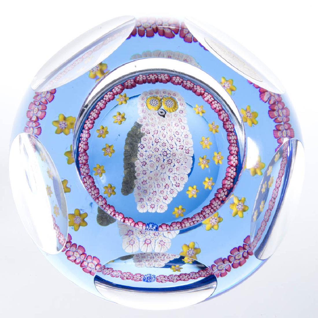 CONTEMPORARY WHITEFRIARS OWL MILLEFIORI PAPERWEIGHT: CONTEMPORARY WHITEFRIARS OWL MILLEFIORI PAPERWEIGHT, colorless, cut-facet, polychrome millefiori canes making up the outline of an owl flanked by yellow floral millefiori canes, outer circle of rose a