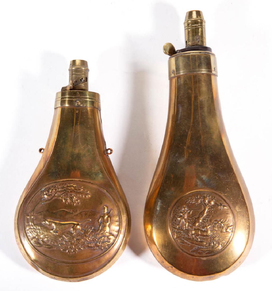 ASSORTED BRASS POWDER FLASKS, LOT OF TWO: ASSORTED BRASS POWDER FLASKS, LOT OF TWO, each with embossed hunting scene decoration, one marked with the Sykes Patent. 19th century. 6 1/2" and 8" LOA.Very good overall condition, with expected usag