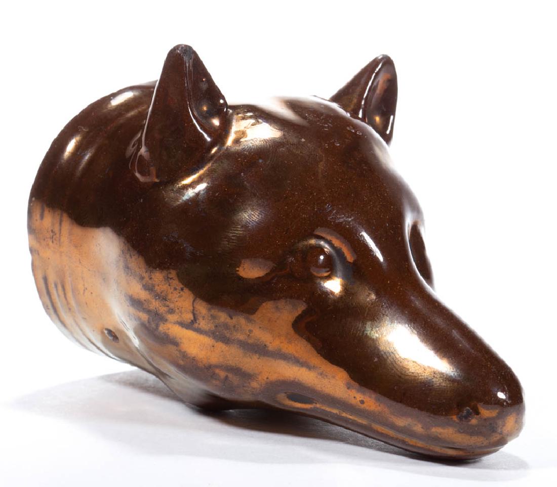 ENGLISH COPPER LUSTRE CERAMIC FOX STIRRUP CUP: ENGLISH COPPER LUSTRE CERAMIC FOX STIRRUP CUP with upright ears and molded collar. Circa 1830. 4 3/4" HOA, 2 2/3" D.Flake on both ear tips and muzzle, with some wear spots on neck. One ear uncentered,