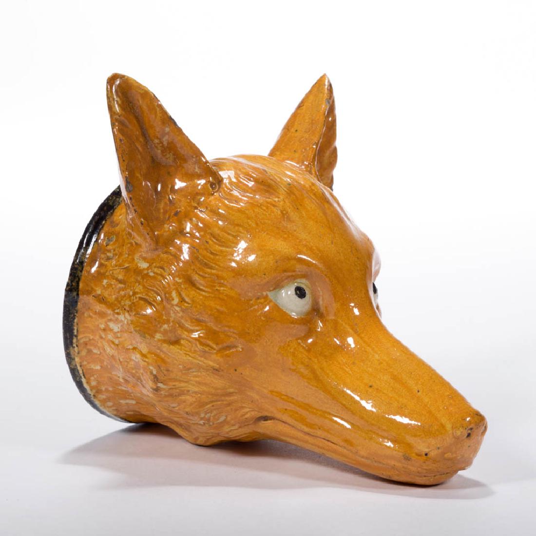 ENGLISH STAFFORDSHIRE PEARLWARE CERAMIC FOX STIRRUP CUP: ENGLISH STAFFORDSHIRE PEARLWARE CERAMIC FOX STIRRUP CUP highly detailed hand-painted features, with a brown banded rim. Fourth quarter 18th century. 4 1/3" HOA, 2 1/2" D rim.Three minor flakes on ears