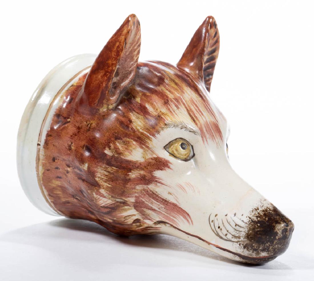 ENGLISH STAFFORDSHIRE PEARLWARE CERAMIC FOX STIRRUP CUP: ENGLISH STAFFORDSHIRE PEARLWARE CERAMIC FOX STIRRUP CUP detailed polychrome hand-painted features including golden eyes, with a thin gilt band around base. Circa 1820. 4 3/4" HOA, 2 7/8" D.Some wear t