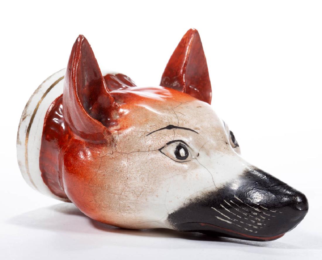 ENGLISH STAFFORDSHIRE CERAMIC FOX STIRRUP CUP: ENGLISH STAFFORDSHIRE CERAMIC FOX STIRRUP CUP with detailed polychrome hand-painted features and a gold gilt banded collar. Kent and Parr. Circa 1880. 5 1/2" HOA.Moderate crazing with areas of restora