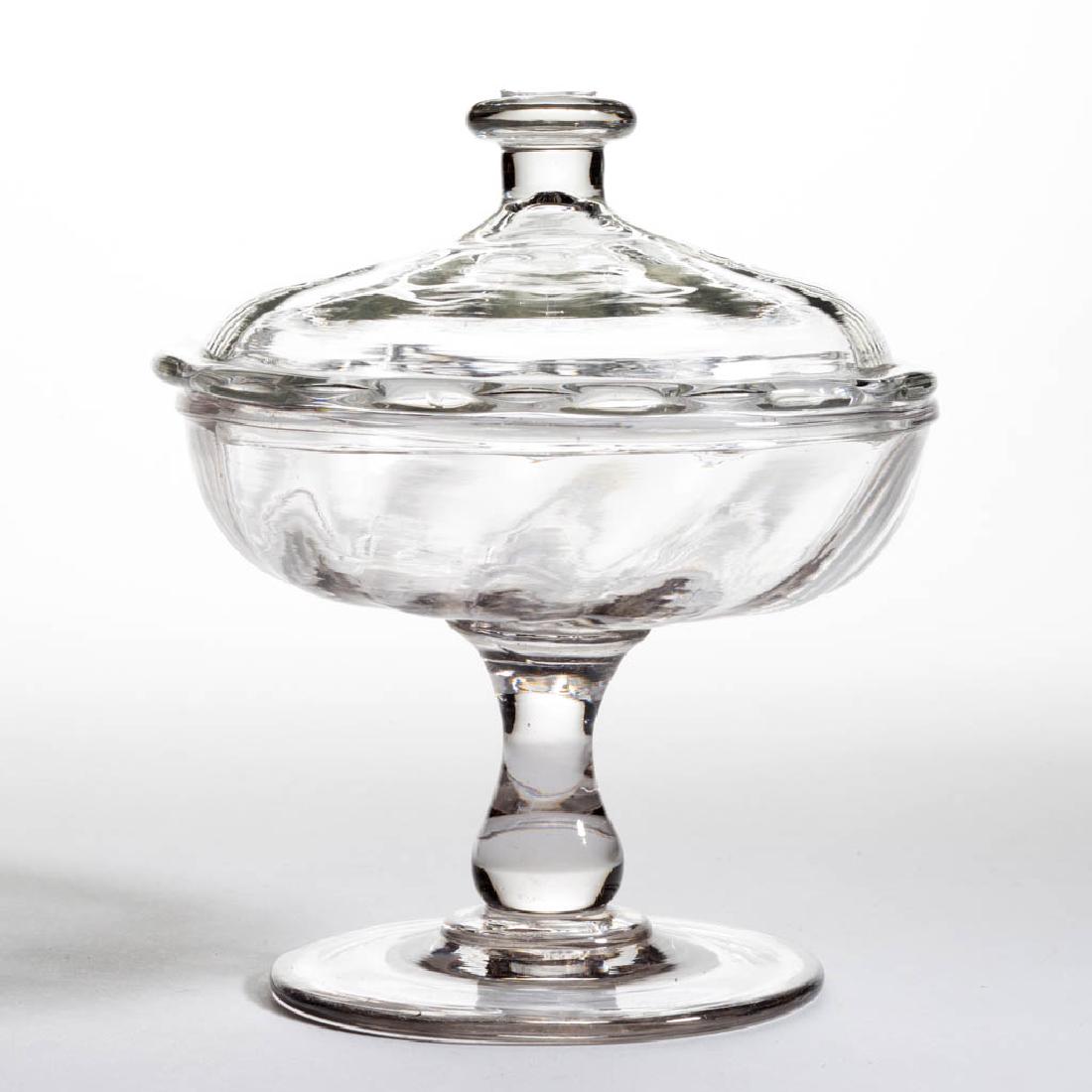 PATTERN-MOLDED COVERED SWEETMEAT COMPOTE: PATTERN-MOLDED COVERED SWEETMEAT COMPOTE, colorless, shallow bowl with 12 ribs and a delicate folded rim, raised on an applied baluster-form stem and circular foot, low-dome 12-rib cover with a drawn 