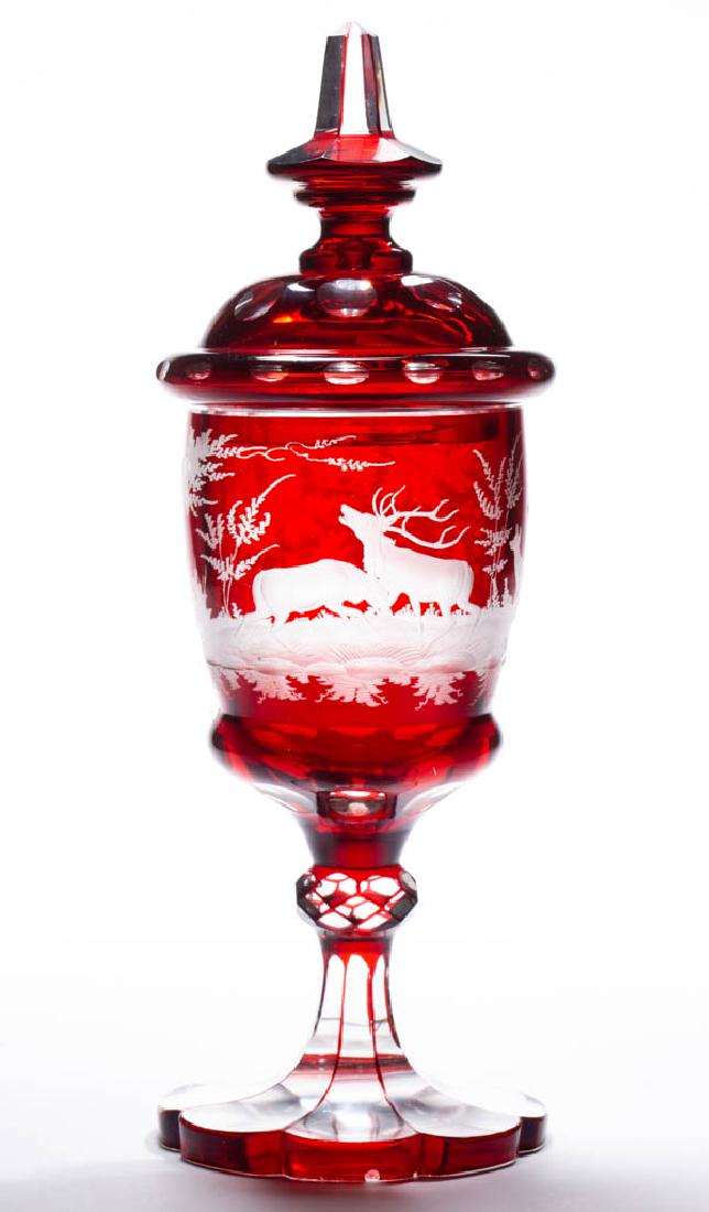 BOHEMIAN CUT OVERLAY AND ENGRAVED - RUBY-STAINED POKAL: BOHEMIAN CUT OVERLAY AND ENGRAVED - RUBY-STAINED POKAL, colorless, ovoid bowl with ornate decoration depicting two bucks fighting with two does looking on in a forest setting, raise on a cut-faceted k