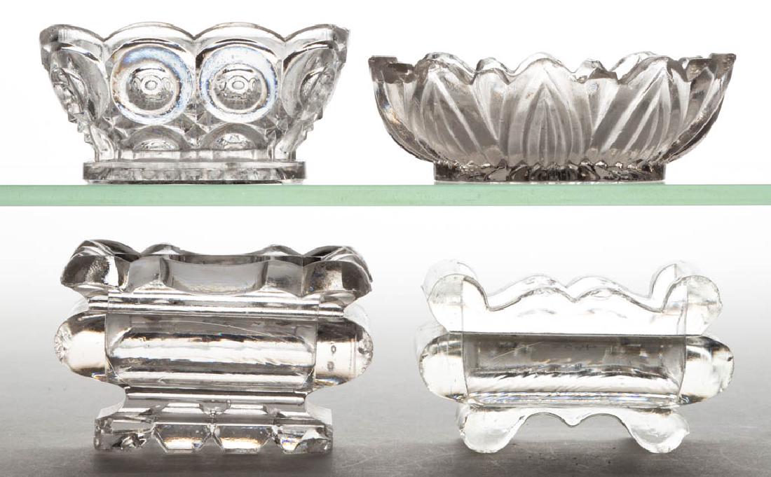 ASSORTED PRESSED GLASS OPEN SALTS, LOT OF FOUR: ASSORTED PRESSED GLASS OPEN SALTS, LOT OF FOUR, colorless lead glass, comprising a Bull's Eye and Sawtooth-type, an Arches, and two heavy rectangular-form examples. Various makers. 19th century. 1 3/8