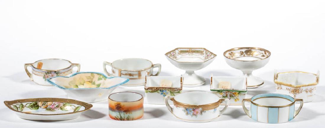 NIPPON PORCELAIN OPEN SALTS, LOT OF 12: NIPPON PORCELAIN OPEN SALTS, LOT OF 12, two unmarked, others with assorted printed marks. First quarter 20th century. 1/2" to 1 1/2" H. Handled hexagonal example with crack, remainder undamaged, some 