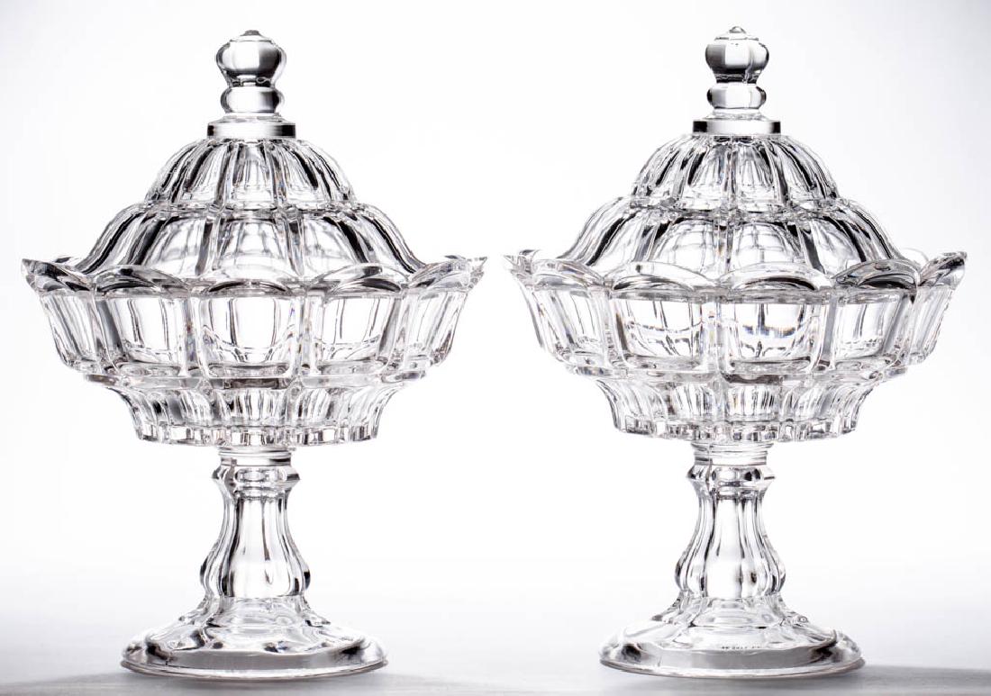 BIGLER - GROOVED COVERED COMPOTES, LOT OF TWO: BIGLER - GROOVED COVERED COMPOTES, LOT OF TWO, colorless lead glass, each with a baluster-form standard and circular foot, wafer construction. Third quarter 19th century. 11" HOA, 8 1/8" DOA rims, 4 5
