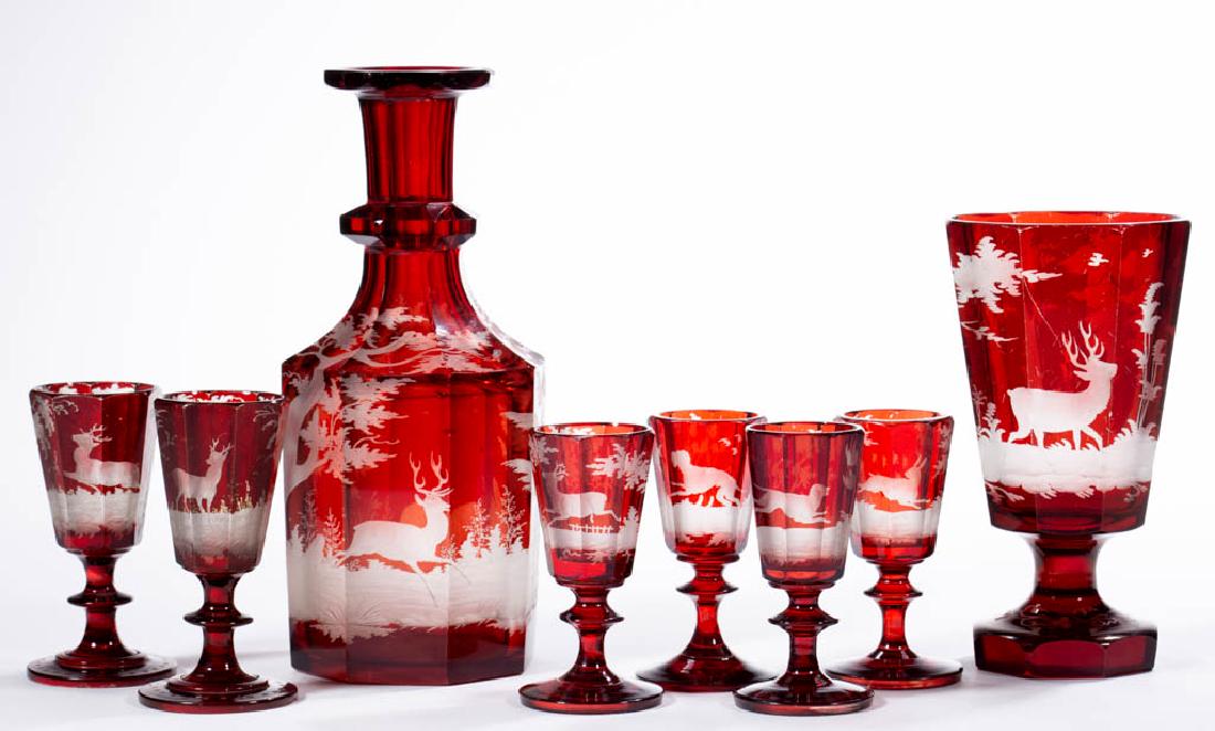ASSORTED BOHEMIAN ENGRAVED - RUBY-STAINED DRINKING: ASSORTED BOHEMIAN ENGRAVED - RUBY-STAINED DRINKING ARTICLES, LOT OF EIGHT, colorless, comprising a decanter, a footed tumbler, and six wine glasses, each with decoration depicting an outdoor scenes wi