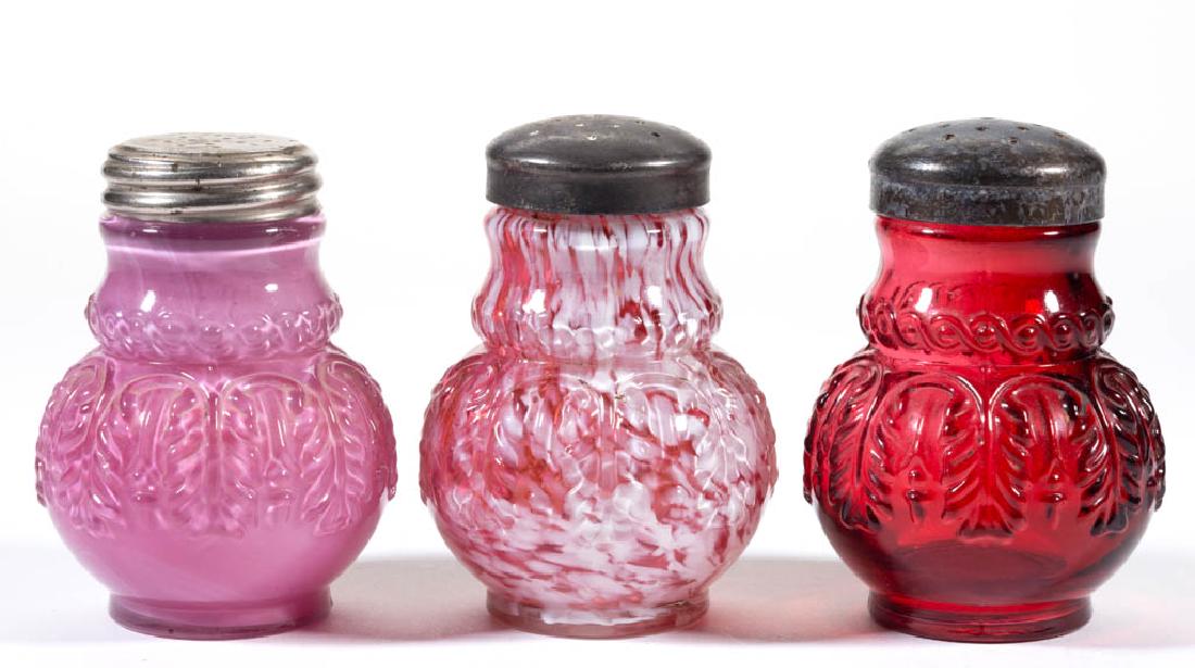 NORTHWOOD NO. 263 / LEAF UMBRELLA SALT AND PEPPER: NORTHWOOD NO. 263 / LEAF UMBRELLA SALT AND PEPPER SHAKERS, LOT OF THREE, cased Rose Du Barry, cranberry with opal spatter, and ruby, each with a period lid. Northwood Glass Co. Pattern introduced 1889