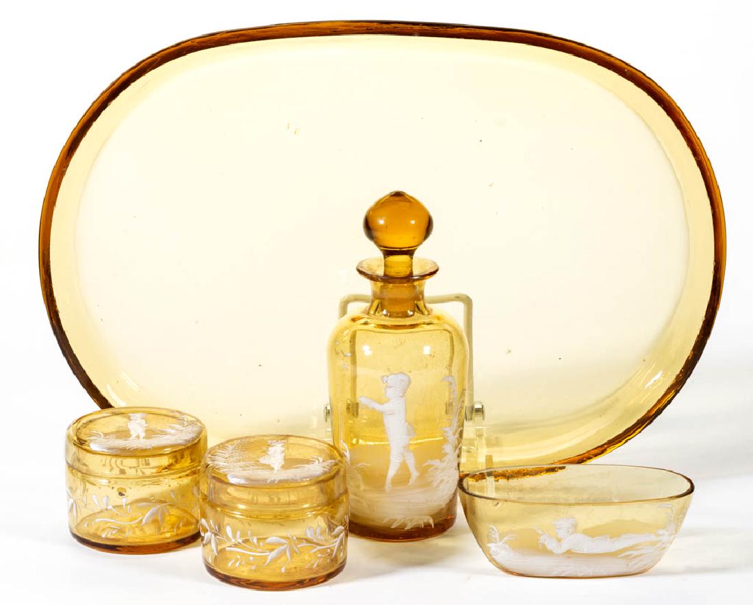MARY GREGORY (SO-CALLED) DECORATED FIVE-PIECE DRESSER: MARY GREGORY (SO-CALLED) DECORATED FIVE-PIECE DRESSER SET, amber with enamel decoration, comprising a perfume bottle, two puff jars, a dresser dish, and a tray. Maker unverified. Late 19th/early 20th 