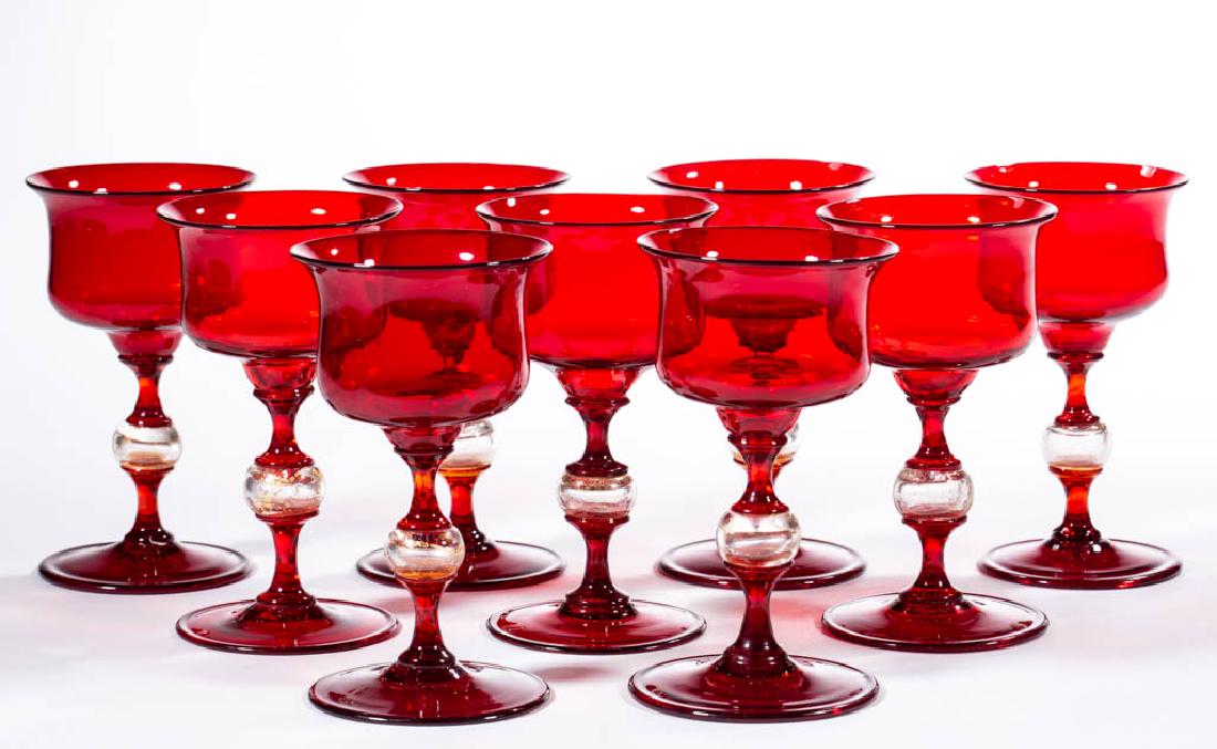 ITALIAN BLOWN GLASS WINE GLASSES, SET OF NINE: ITALIAN BLOWN GLASS WINE GLASSES, SET OF NINE, ruby, each with cylindrical bowl having slightly flared rim, central hollow stem with aventurine decoration, and a circular foot. Probably Murano, Italy.