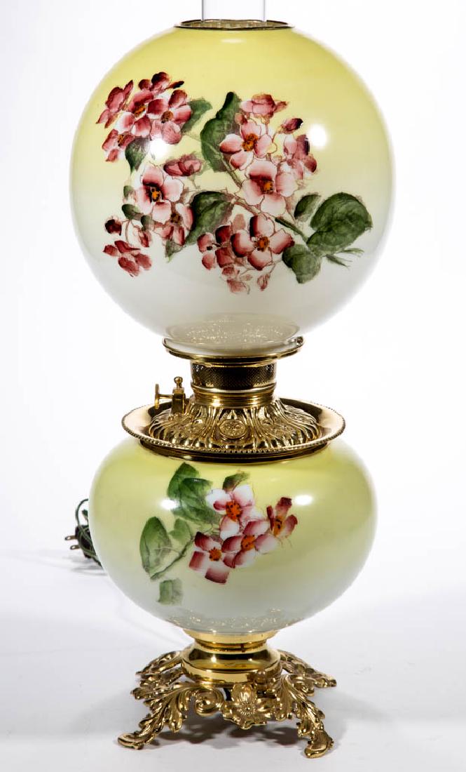 FOSTORIA ENAMEL-DECORATED PARLOR / GONE WITH THE WIND: FOSTORIA ENAMEL-DECORATED PARLOR / GONE WITH THE WIND LAMP, opaque white with dark to light lemon yellow shading and polychrome dogwood decoration, matching decorated ball-form shade with brass heat r