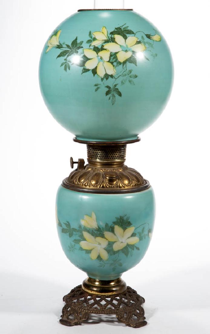VICTORIAN ENAMEL-DECORATED PARLOR / GONE WITH THE WIND: VICTORIAN ENAMEL-DECORATED PARLOR / GONE WITH THE WIND LAMP, opaque white with teal green ground and waterlily stencil decoration, matching decorated ball-form shade with brass heat ring; elongated-fo