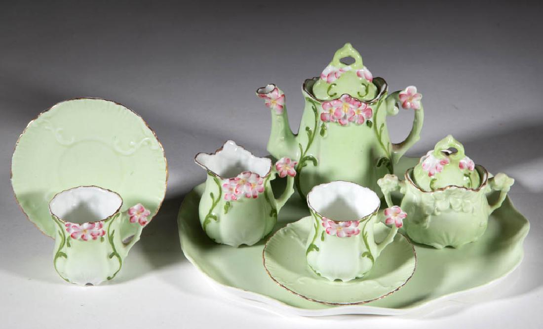 GERMAN PORCELAIN "FLORAL CABARET" CHILDREN'S TOY: GERMAN PORCELAIN "FLORAL CABARET" CHILDREN'S TOY EIGHT-PIECE TEA SET, comprising a covered teapot, a 3" HOA covered sugar, a creamer, a tray, and two cups and saucers, each with delicate pink flowers