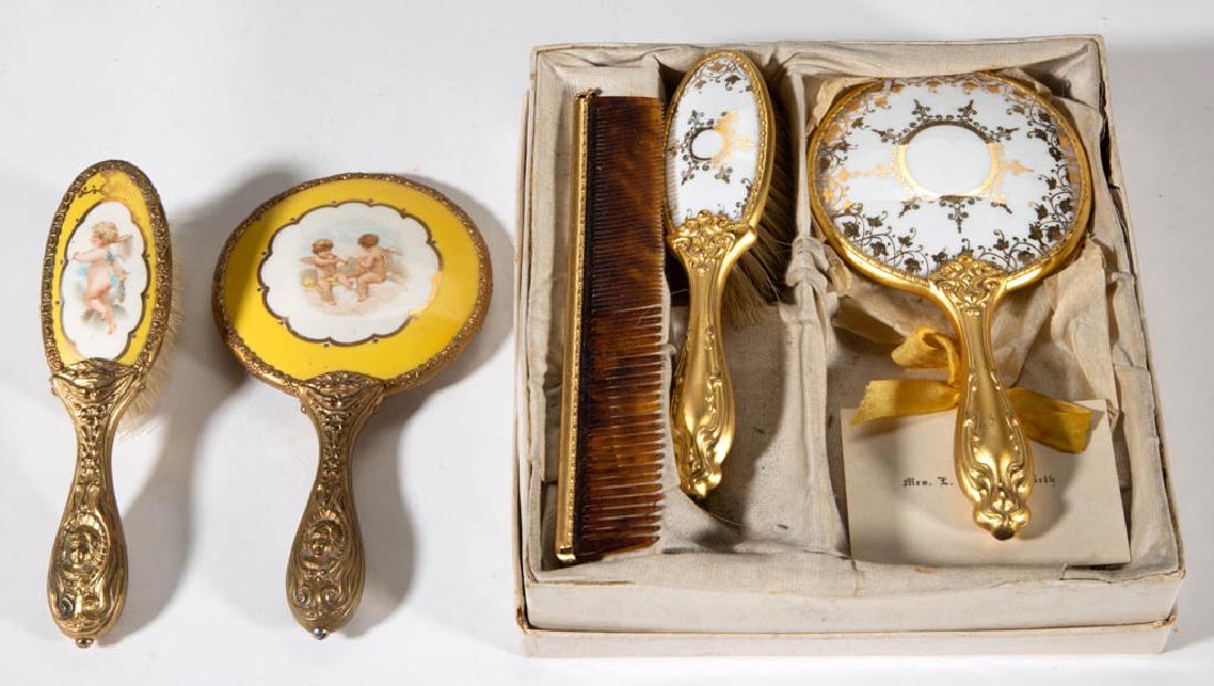 ASSORTED GILT-DECORATED CHILDREN'S TOY DRESSER: ASSORTED GILT-DECORATED CHILDREN'S TOY DRESSER ARTICLES, LOT OF FIVE, comprising a comb, a porcelain inset hand mirror, and a hair brush set with gilt foliate decoration and impressed "GERMAN SILVER"