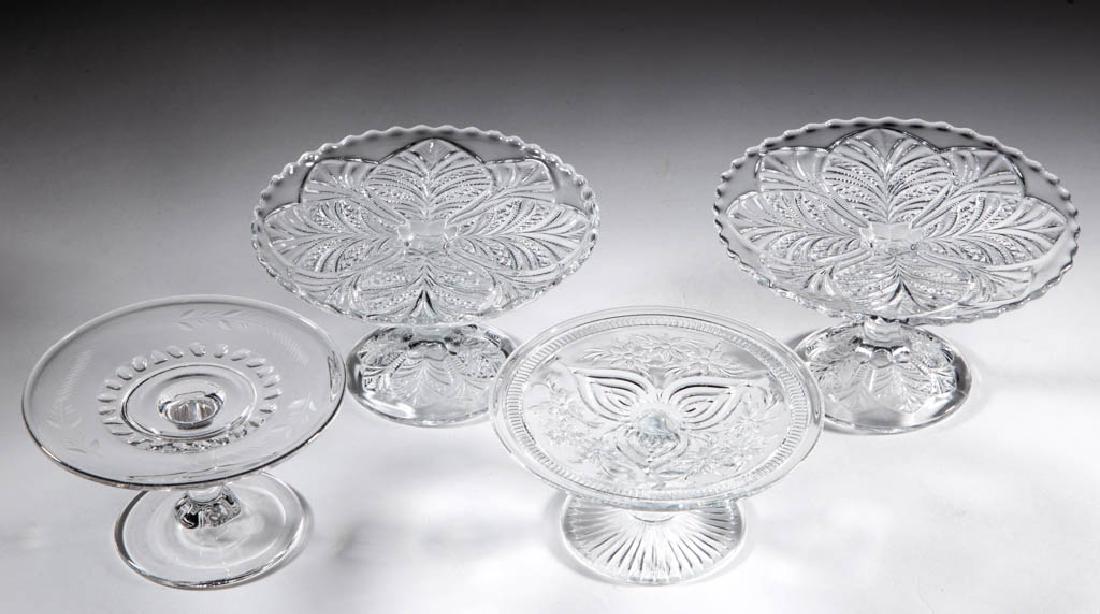 ASSORTED PRESSED CHILDREN'S GLASS TOY SALVERS / CAKE: ASSORTED PRESSED CHILDREN'S GLASS TOY SALVERS / CAKE STANDS, LOT OF FOUR, colorless, comprising Thumbprint Variation, Flower with Band, and two Palm Leaf Fan examples. Various makers. Fourth quarter 1