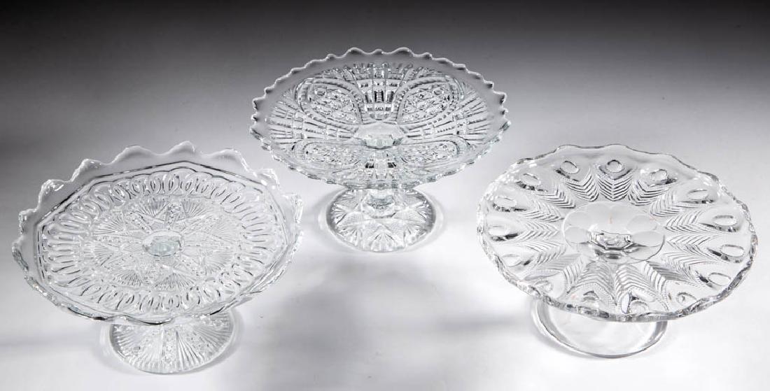 ASSORTED PRESSED CHILDREN'S GLASS TOY SALVERS / CAKE: ASSORTED PRESSED CHILDREN'S GLASS TOY SALVERS / CAKE STANDS, LOT OF THREE, colorless, comprising a Peacock Feather, an unidentified star-motif pattern, and a Arrowhead and Oval. Various makers. Fourth